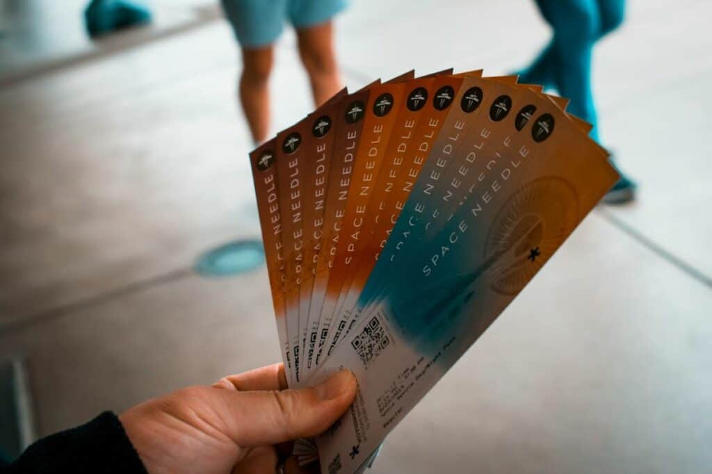 Fan of Space Needle event tickets held in hand