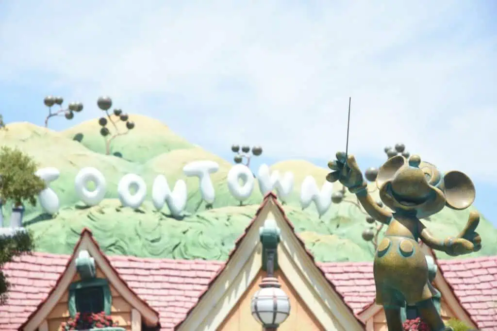 Cartoon-style buildings with "Toontown" sign and Mickey Mouse statue